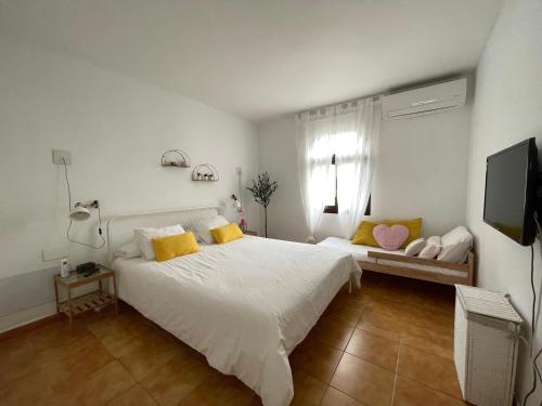 a bedroom with a white bed with yellow pillows at Teguisol 258, Apt. with terrace, near the beach in Costa Teguise