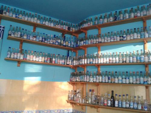 una pared llena de estanterías llenas de muchas botellas en The Colourful Mansion Hotel, en Ahtopol