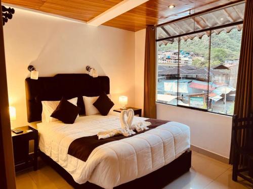 1 dormitorio con cama grande y ventana grande en SAYACMARCA CLASSIC Inn, en Machu Picchu