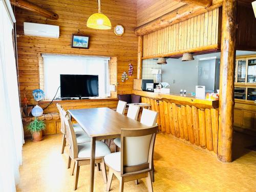 ein Esszimmer mit einem Tisch und Stühlen in der Unterkunft 民泊JOYFUL天然温泉付きログハウス in Shiraoi
