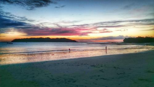 a sunset on a beach with the ocean at Eco-Lodge Deseo Bamboo in Santa Catalina