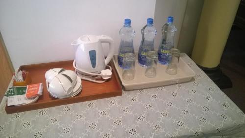 a table with bottles of water and a tea kettle at No.53 in Katunayake