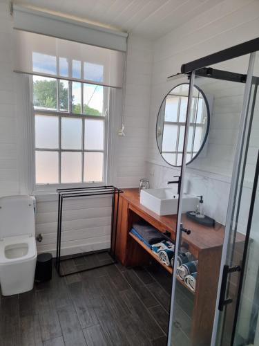 uma casa de banho com um lavatório e um espelho em Miners Cottage Beechworth em Beechworth