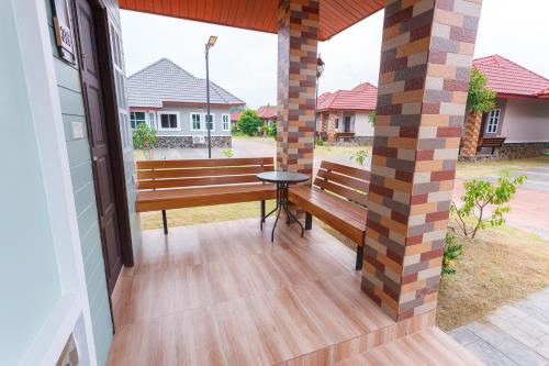 a porch with a wooden bench and a table at Avarin Resort in Pak Chong