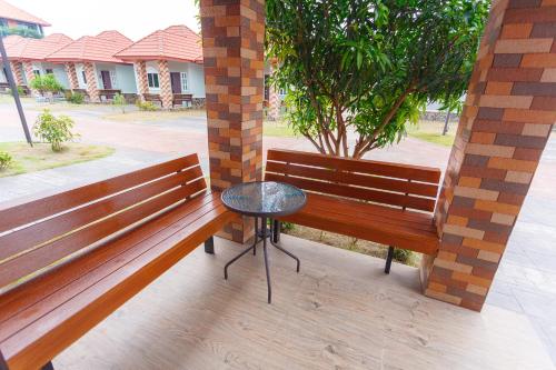 a patio with two benches and a small table at Avarin Resort in Pak Chong