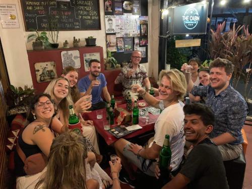 un groupe de personnes assises autour d'une table en train de boire du champagne dans l'établissement The Cabin Backpackers Hostel & Bar, à Chiang Mai