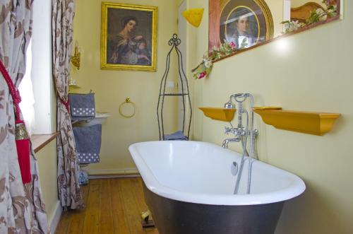 
a bathroom with a tub, sink, and mirror at Chambres d'hôtes Villa l'espérance in Étretat
