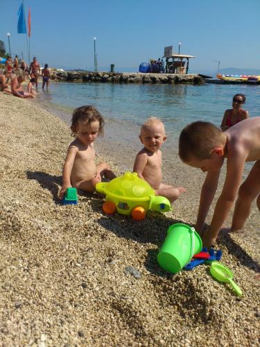 three children playing in the sand at the beach at Art Studios Benitses in Benitses
