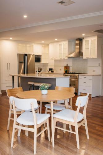 a kitchen with a wooden table and chairs at Banksia by the Bay in Emu Point