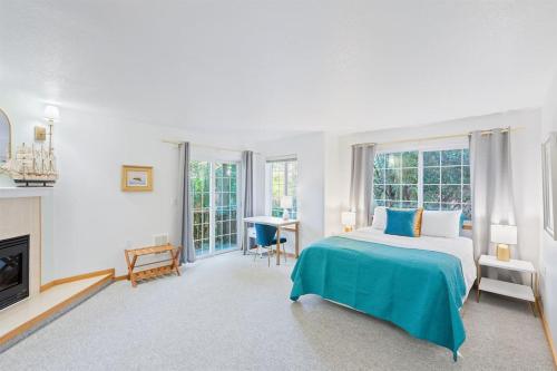 a white bedroom with a bed and a fireplace at Cannon beach vibes, steps to the beach,WIFI,3 full bedroom en suites with 3 fireplaces,Near Downtown in Cannon Beach