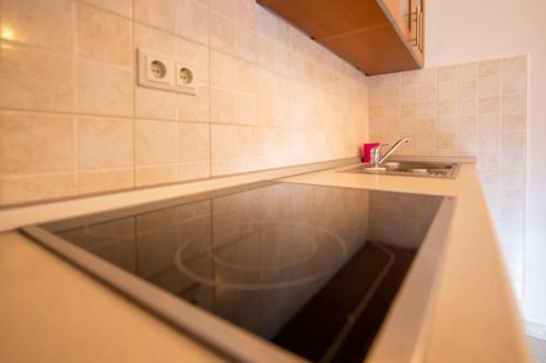 a kitchen with a sink and a counter top at Apartments Den - 100 m from sea in Pašman