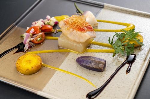 a plate of food with cheese and vegetables on it at Ishinoya Izunagaoka - TKP Hotels & Resorts in Izunokuni