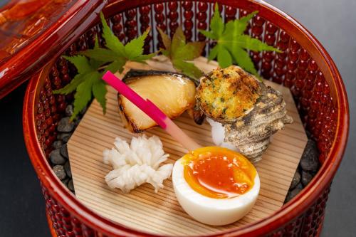 a basket of food with an egg and meat at Ishinoya Izunagaoka - TKP Hotels & Resorts in Izunokuni