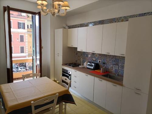 een keuken met witte kasten en een tafel en stoelen bij Appartamento tra San Pietro e Castel S.Angelo in Rome