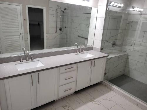 a bathroom with two sinks and a shower and a mirror at 5 bed 3.5 baths in Las Vegas