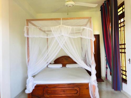 a bed with a canopy in a room at Sudumal Cottage in Ella