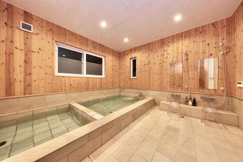 a large bathroom with a tub and a shower at Crystal Besso Shirahama in Shirahama