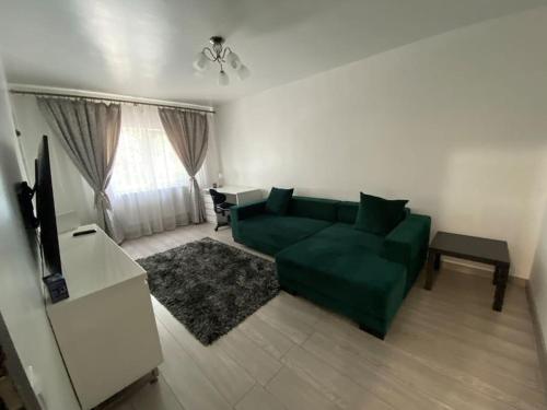 - un salon avec un canapé vert et une table dans l'établissement The Urban Hub 1, à Iaşi
