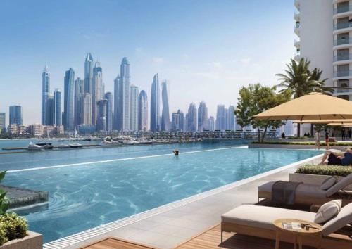 een zwembad met een skyline van de stad op de achtergrond bij Ultra Luxury Emaar Beachfront - Private Beach and Pool in Dubai