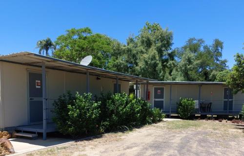a small building with trees in the background at Taroom Caravan & Tourist Park in Taroom