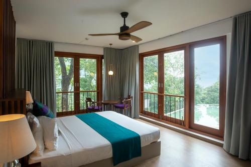 a bedroom with a bed and a balcony at Birds Park Polgahawela in Egalla