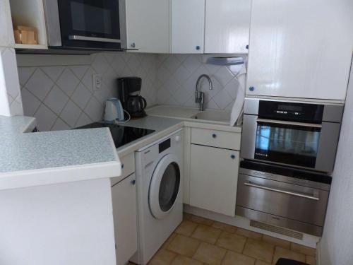 Il comprend une cuisine équipée d'un lave-linge, d'un évier et d'un lave-vaisselle. dans l'établissement Joli Appartement au Lavandou Centre - 2 Chambres, Terrasse Sud et Garage - FR-1-308-109, au Lavandou
