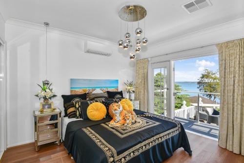 a bedroom with a bed with a view of the ocean at Waterfront Entertainers Haven in Toukley