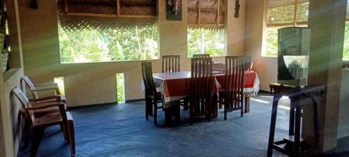 a dining room with a red table and chairs at Lavista Holiday Bungalow in Wellawaya