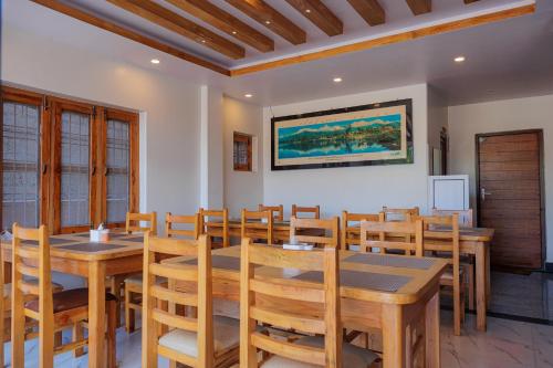una sala da pranzo con tavoli e sedie in legno di Hotel Sandalwood a Pokhara