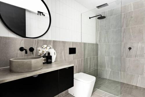 a bathroom with a sink and a toilet and a mirror at New York Converted Warehouse Apartment in Richmond in Melbourne