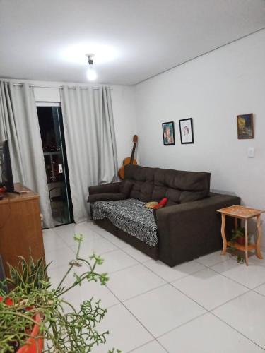 a living room with a brown couch and a table at Hostel e Pousada Casarão - Parnaíba in Parnaíba