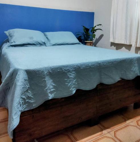 a bedroom with a bed with a blue wall at Hostel e Pousada Casarão - Parnaíba in Parnaíba