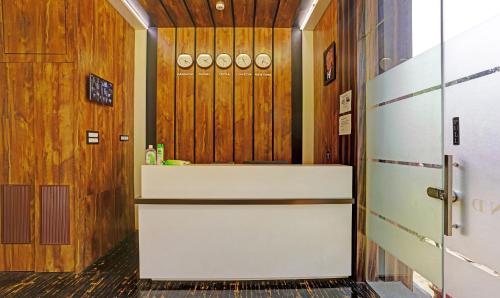 a bathroom with a white counter and wooden walls at Treebo Trend Prime Grand, Andheri in Mumbai