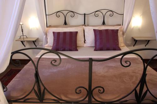 Una cama con almohadas moradas y blancas. en InChiostro Rooms&Breakfast, en Padua