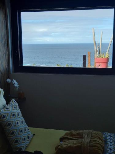 a view of the ocean from a bedroom window at CHAMBRE CHEZ L HABITANT PISCINE VUE MER SDB et TERRASSE PRIVEE laverie in Saint-Pierre