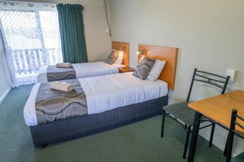 a hotel room with two beds and a table and a desk at Halfway Motel in Eden