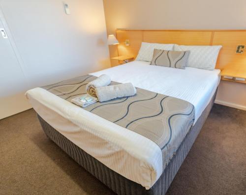 a large bed with two towels on it in a room at Halfway Motel in Eden