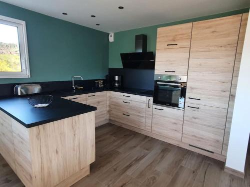 a kitchen with wooden cabinets and a black counter top at La maison d'Elodie in Foncine-le-Haut