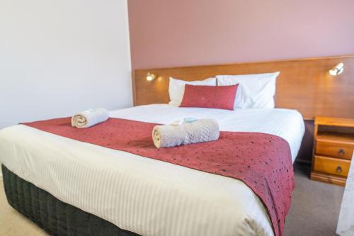 a bedroom with a large bed with two towels on it at Halfway Motel in Eden