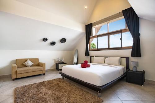 una camera da letto con un letto, una sedia e una finestra di Beautiful 5BR Villa Felicity, Pool & Garden, near Naiharn a Rawai Beach