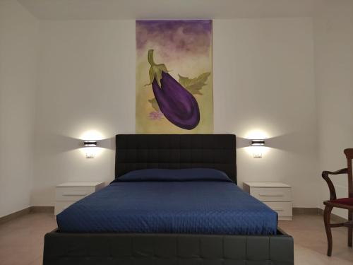 a bedroom with a bed and a painting on the wall at Agriturismo Ariston ONC 1484 in Sabaudia