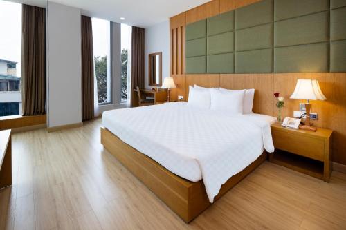 a bedroom with a large bed and a large window at Eden Star Saigon Hotel in Ho Chi Minh City