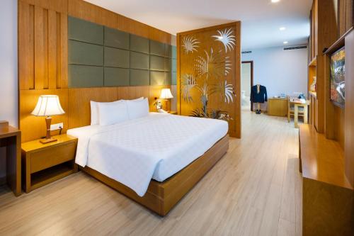 a bedroom with a large white bed and a desk at Eden Star Saigon Hotel in Ho Chi Minh City