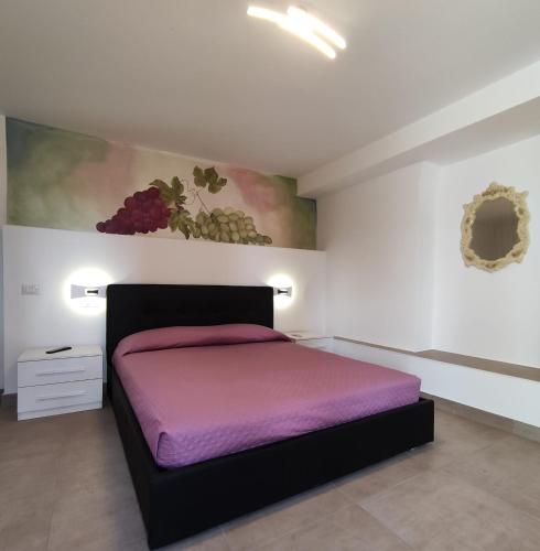 a bedroom with a bed with purple sheets and a painting at Agriturismo Ariston ONC 1484 in Sabaudia