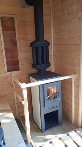a wood fired stove in a wooden room at Panna tanya in Tahitótfalu