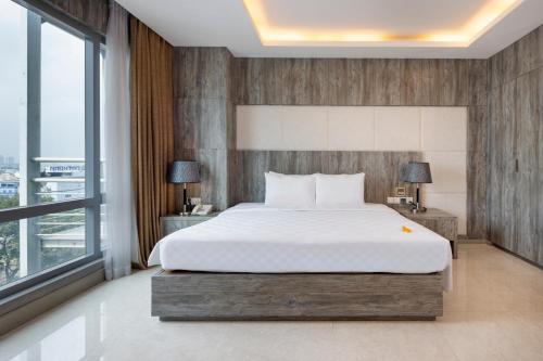 a bedroom with a large bed and a large window at Eden Star Saigon Hotel in Ho Chi Minh City