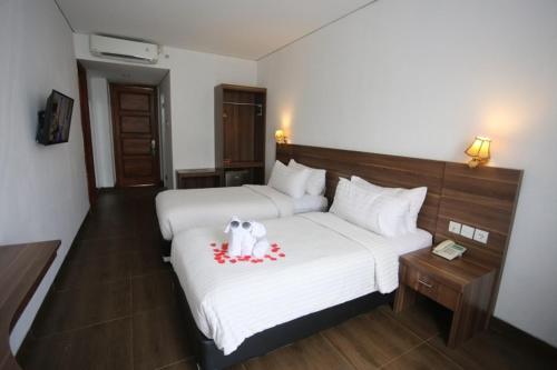 a hotel room with a bed with a stuffed dog on it at Azza Hotel Palembang in Palembang