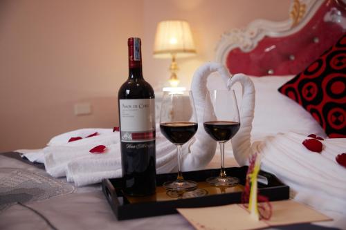 a bottle of wine and two glasses on a tray at Lucky Budda Inn Villa in Hanoi