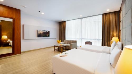 a hotel room with a bed and a living room at Eden Star Saigon Hotel in Ho Chi Minh City