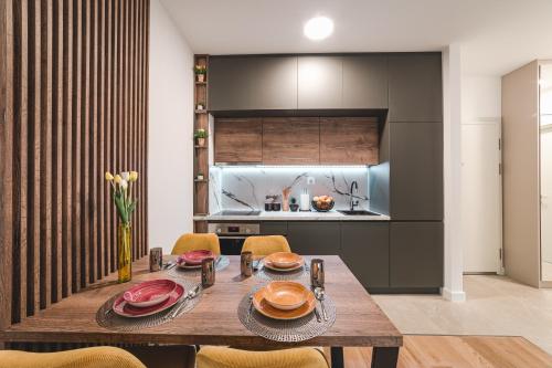 Un comedor con una mesa de madera y una cocina. en ZAFIRO SPA & RESIDENCE, en Budva